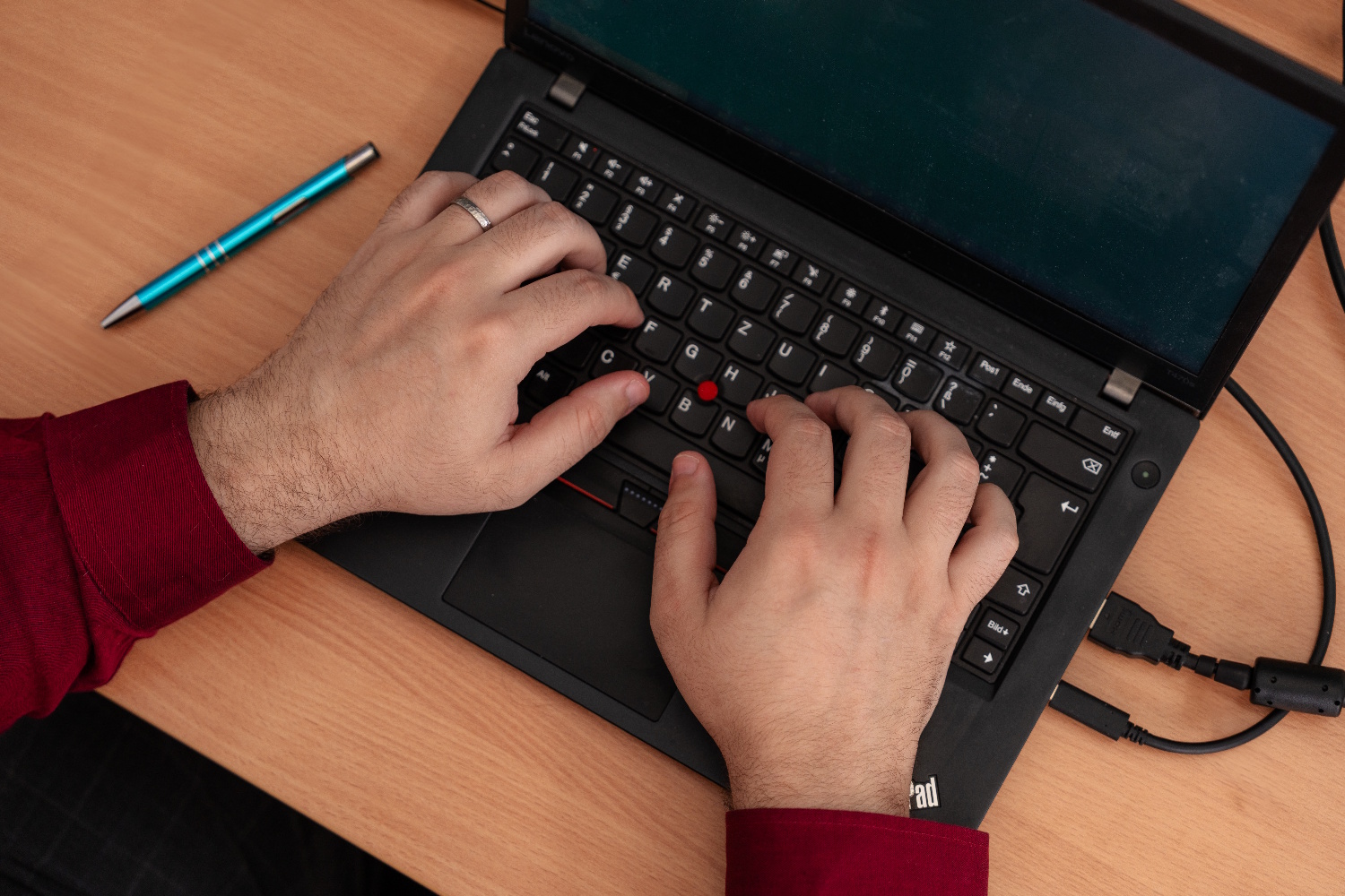 Erik Löwen arbeitet bei NEOVER am Laptop, Hände auf der Tastatur